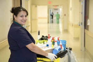 custodian janitor in hospital hallway with cart
