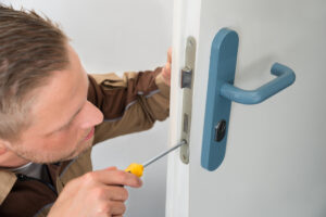 portrait,young,male,carpenter,repairing,door,lock